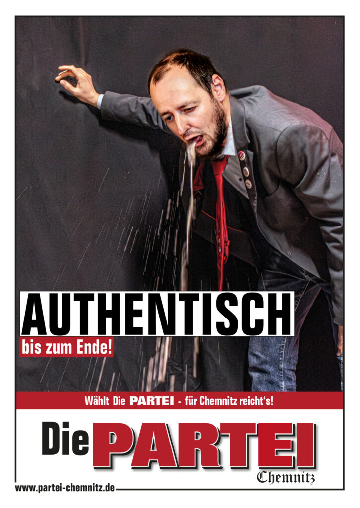 Ein Plakat von Die PARTEI, darauf sieht man einen Mensch im grauen Anzug und roter Krawatte an eine Wand gelehnt kotzen. Auf dem Plakat steht der Schriftzug "Authentisch - bis zum Ende!"