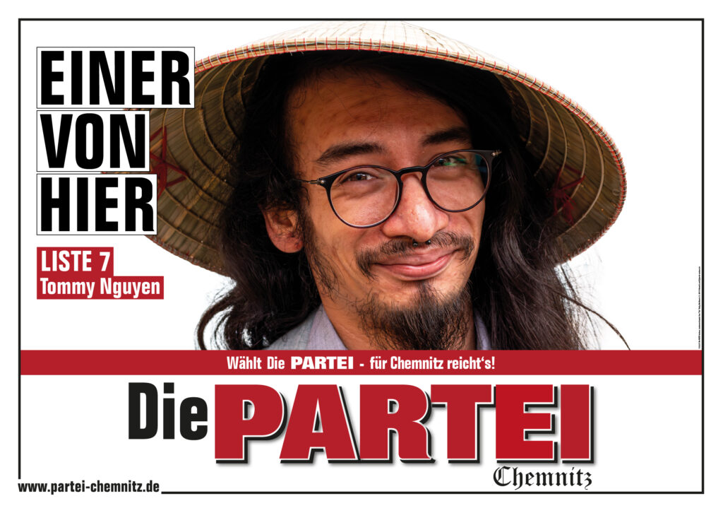 Ein Plakat von Die PARTEI im Querformat. Auf weißem Hintergrund sieht man einen Mann mit langen schwarzen Haaren, Kinnbart, einem Reishut und asiatischen Gesichtszügen. Daneben der Schriftzug "Einer von hier! - Liste 7 - Tommy Nguyen"